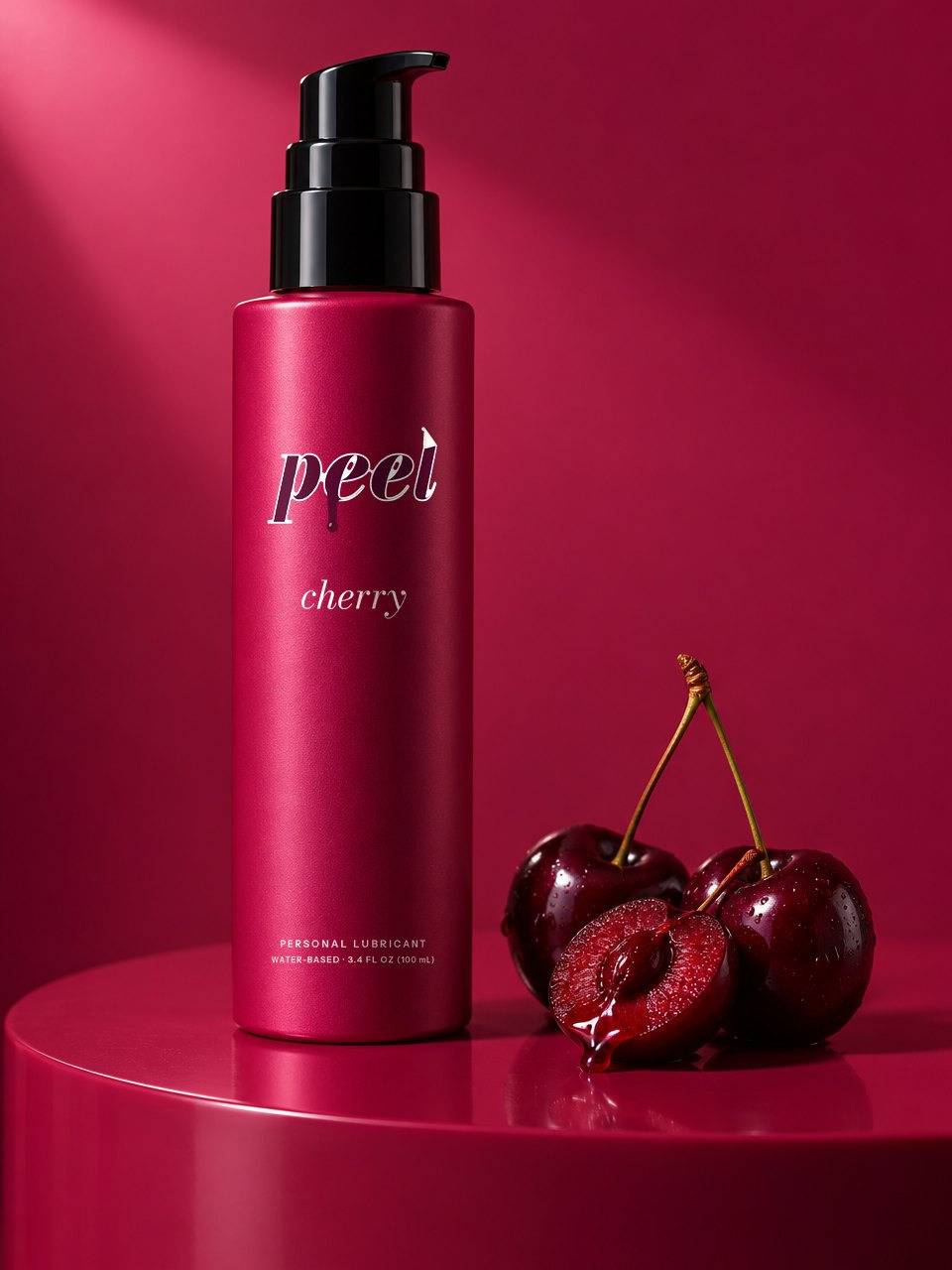 PEEL cherry: a fuchsia sleeved bottle with a black pump on a fuchsia set, beside dark cherries